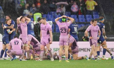 Scotland’s dejected players look on in disbelief as Italy celebrate a famous win in the Roman rain