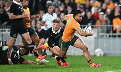 Tom Wright going over to score for Australia in their 50-19 defeat to New Zealand at Eden Park yesterday