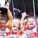 England stars Natasha Hunt and Zoe Aldcroft celebrate as Gloucester-Hartpury’s Sisilia Tuipulotu lifts the trophy last season