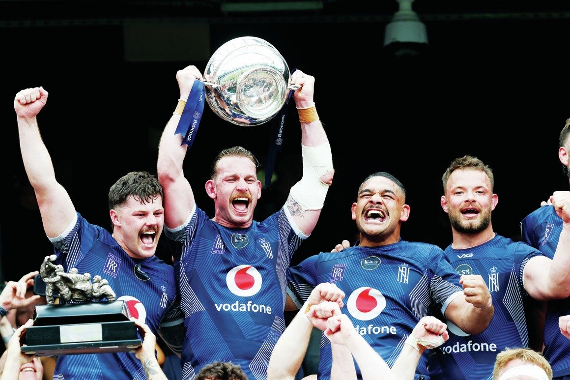 Navy captain Jarrard Hayler lifts the trophy